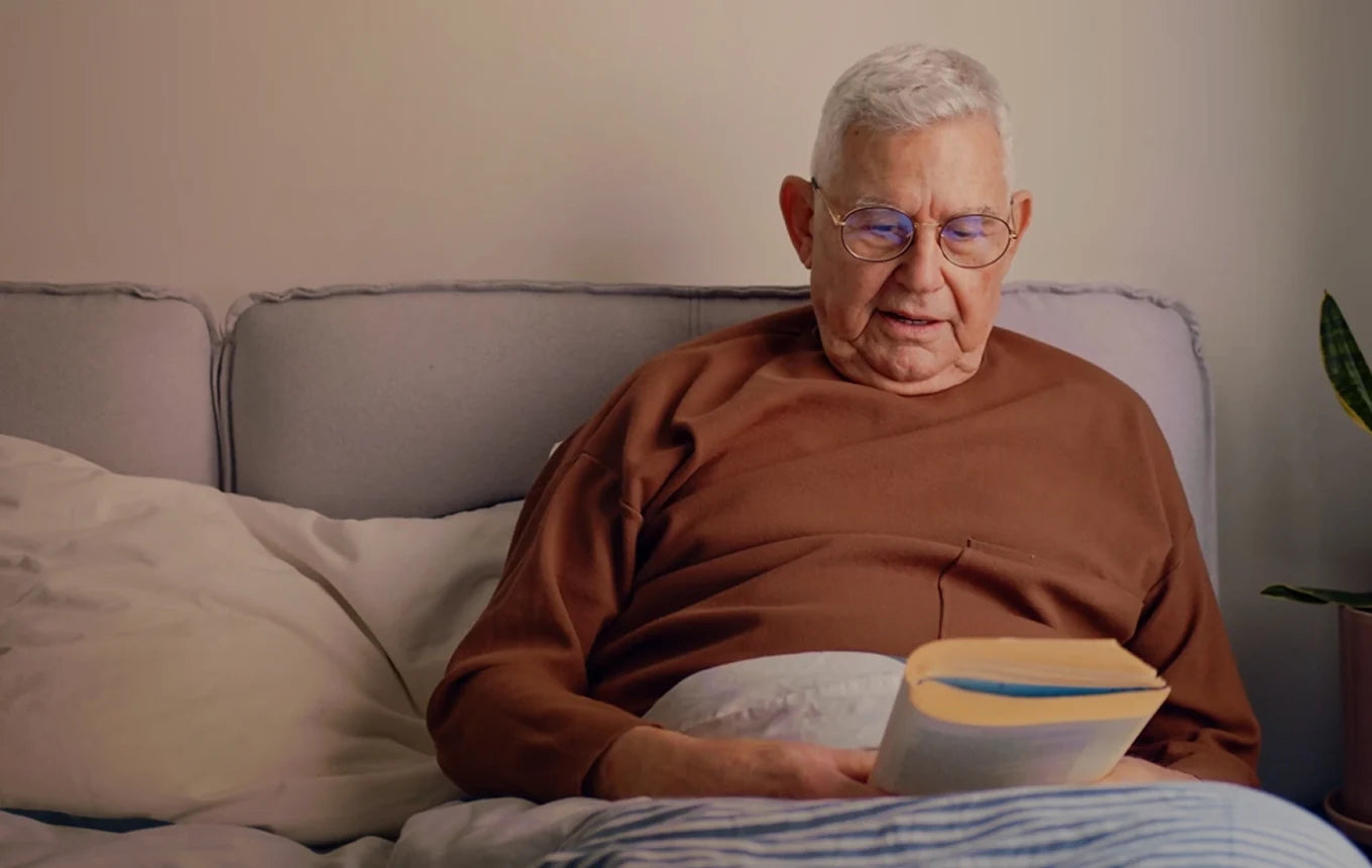 An older man reading in bed at home